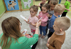 Pani rozdaje dzieciom zakładki do książki