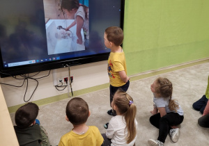 Dzieci oglądają zdjęcia pieska na tablecie