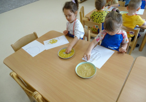 03 Dziewczynki ozdabiają pisankę makaronem