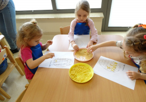 04 Dziewczynki ozdabiają pisankę makaronem