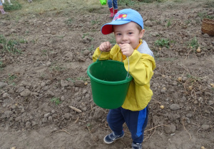 chłopiec stoi z wiaderkiem