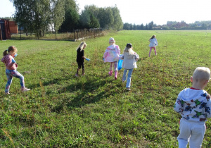 dzieci zbierają śmieci na łące