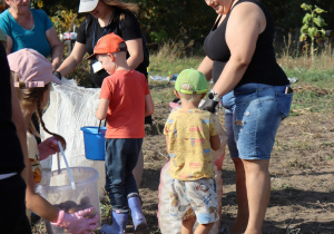 dzieci wrzucają ziemniaki do worka