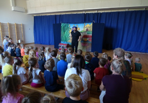 Dzieci oglądają teatrzyk, aktor wita dzieci