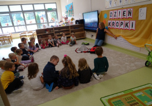 08 Pani pokazuje literę z kropką