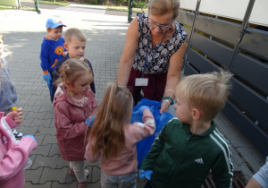18 Dziewczynka wrzuca odpady do worka na śmieci