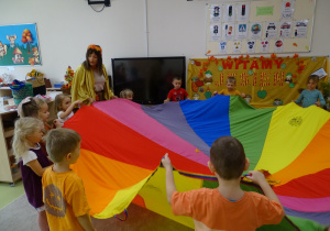 13 Pani Jeień z dziećmi trrzyma chustę animacyjną