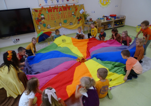 13 Pani Jeień z dziećmi trrzyma chustę animacyjną