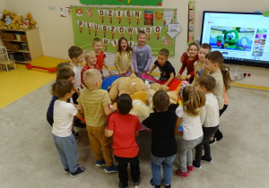 Dzieci huśtają na kolorowej chuście swoje misie