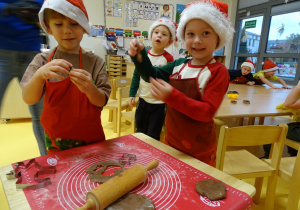 Chłopcy wycinają foremkami pierniczki