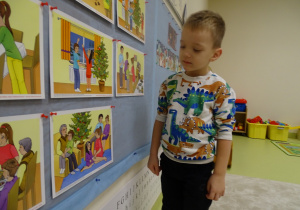04 Chłopiec patrzy na obrazki z tradycjami Świąt Bożego Narodzenia