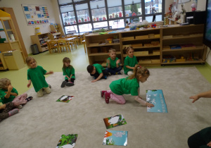21 Dzieci układają planszę o dinozaurach