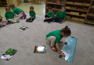 22 Dzieci układają planszę o dinozaurach