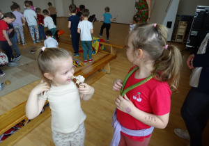 Dziewczynki trzymają na szyi sztuczne węże