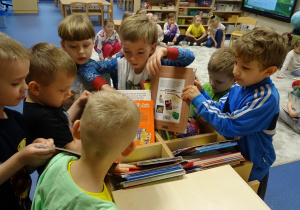 dzieci stoja i szukaja ksiazek
