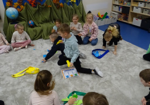 Dzieci wrzucają kartki do szarf