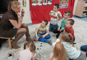 Dzieci słuchają nazw obrazków w zabawie słuchowej