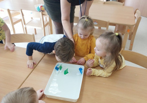 Dzieci wydychają powietrze i poruszają żaglówkami na wodzie