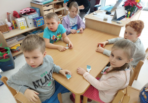Dzieci czekają z żaglówkami na sztuczne jezioro- pojemnik z wodą