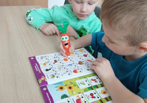 Chłopcy ćwiczą słuch fonematyczny, jeden trzyma w ręku Magiczną Marchewkę
