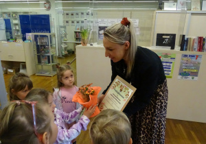 Dzieci wręczają podziękowanie pani bibliotekarce