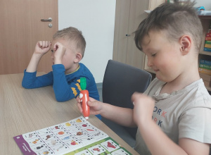 Chłopcy rozwiązują zadnia w książce z Magiczną Marchewką
