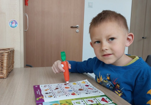 Chłopiec właściwą głoskę z Magiczną Marchewką w dłoni