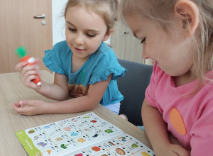 Dziewczynki rozwiązują zadnia w książce z Magiczną Marchewką
