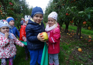 Chłopczyk i dziewczynka trzymają soczyste jabłuszko.