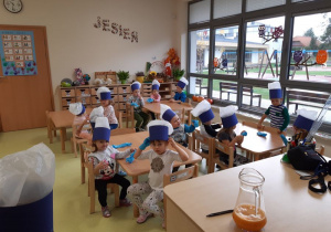 Dzieci czekają przy stolikach na pyszny sok.
