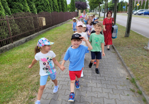 Dzieci w parach idą chodnikiem do ldziarni