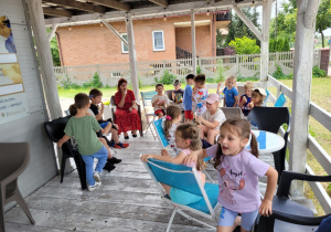 Dzieci siedzą w lodziarni i jedzą lody