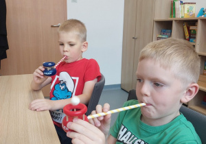 Chłopcy doskonalą oddech na logopedycznej dmuchajce