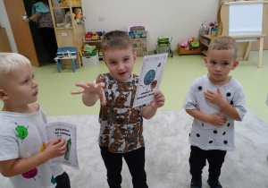 Chłopiec pokazuje kartkę.