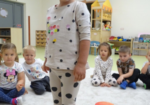 Dziewczynka stoi na niebieskiej kropce.