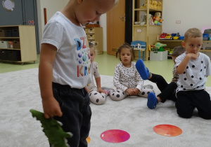 Chłopiec stoi na niebieskiej kropce.