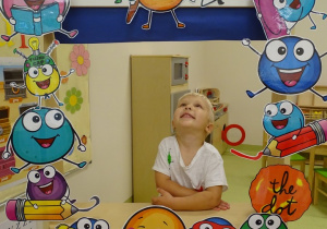 Chłopiec pozuje do zdjęcia w kropkowej ramce.