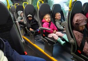 Dzieci siedzą na siedzeniach w autobusie.