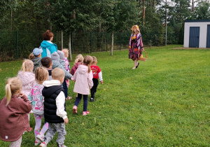 Dzieci zauważyły w oddali panią w kolorowej sukience