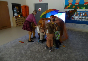 dzieci chowają się pod parasol