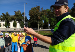 Policjant opoiwada dzieciom o podstawowych zasadach bezpieczeństwa