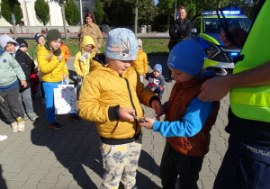 Dzieci oglądają wyposażenie pracy policjanta