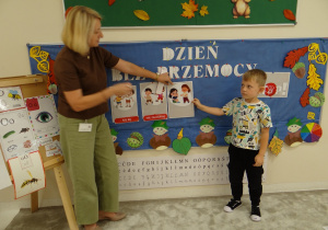 10 Chłopiec z panią podczas zawieszania i omawiania obrazka