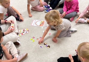 Dziewczynka wkłada owoce i warzywa do koszyka