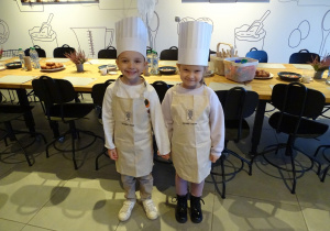 Dzieci ubrane w strój kucharski, fartuszek i czapkę