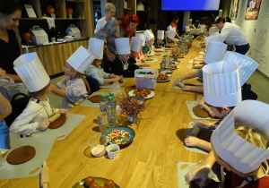 Dzieci wałkują ciasto piernikowe