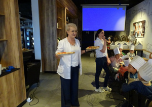 Pani częstuje dzieci pizzą