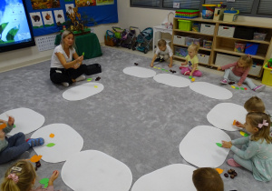 dzieci siedzą n a dywanie