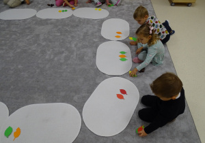 dzieci układają rytmy z kasztanów i liści