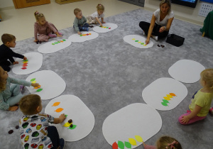 dzieci układają rytmy z kasztanów i liści